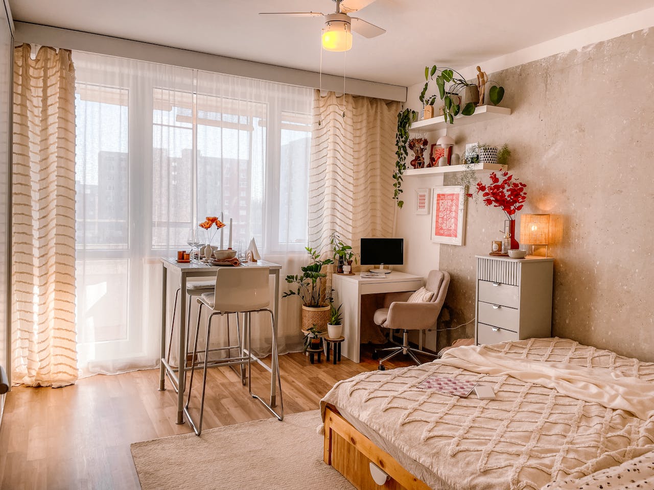 services-02 A bright and cozy Scandinavian-style bedroom with wooden floors, plants, and modern furnishings.